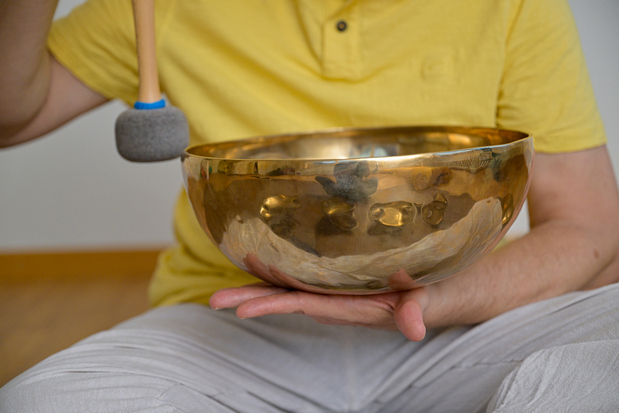 Eine Klangschale wird achtsam angespielt. Klangmassagen von Mitklang (Kriens) sind besonders achtsam und sanft für eine tiefe Entspannung.
